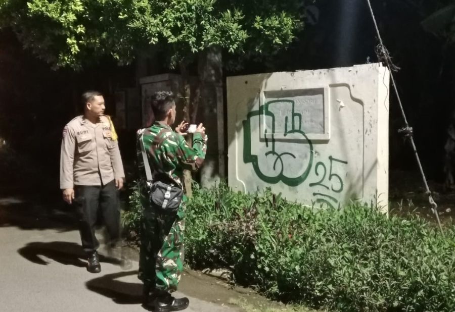 Petugas Bhabinkamtibmas Desa Sumerta Kelod Aipda I Kadek Rudi Martana, S.H., bersama Babinsa Sertu I Gede Mega dan personel Linmas Desa Sumerta Kelod menghapus corat coret tembok yang muncul di Jalan Drupadi, Denpasar, Bali, Kamis (27/11/2025) malam. (foto/hes)
