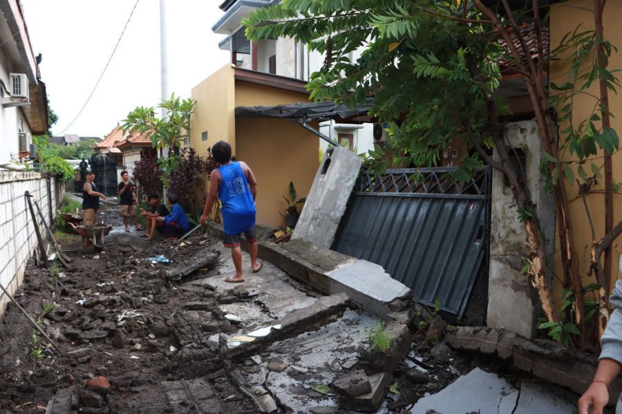 Warga membersihkan puing rumah dan tembok roboh pasca angin puting beliung yang menerjang permukiman padat di Kota Denpasar. (sukadana) 