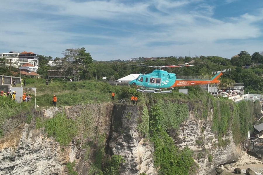 Helikopter beroperasi menyelamatkan dua WNA Rusia yang terjebak di bawah tebing Pantai Cemongkak, Desa Pecatu, Kecamatan Kuta Selatan, Badung, Bali, Kamis (23/4/2026) siang. (foto/hes)
