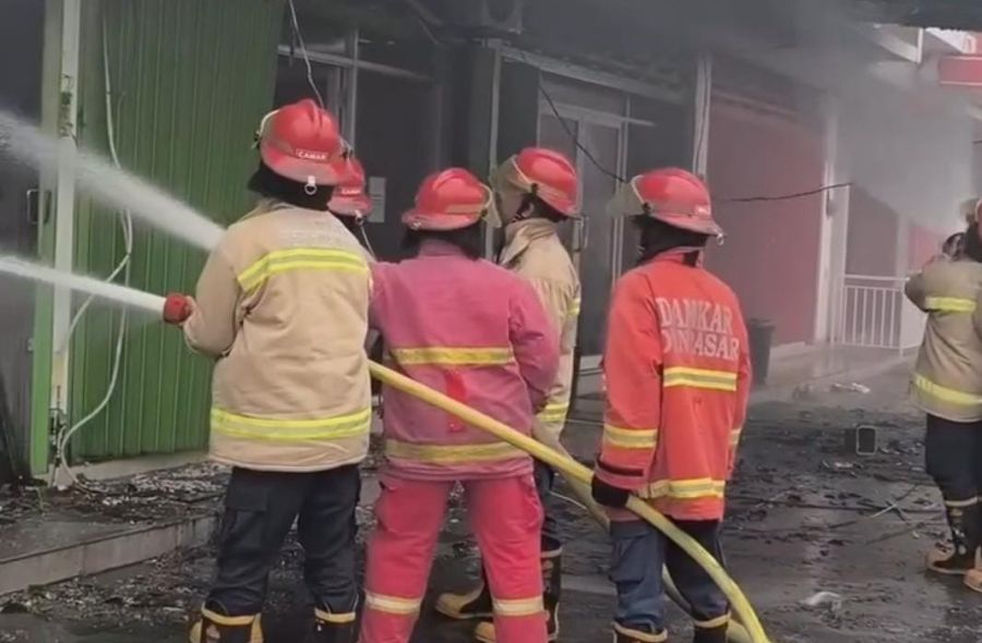 Petugas pemadam kebakaran menangani kebakaran toko pakaian di Jalan Antasura, Denpasar Utara. (foto/hes)