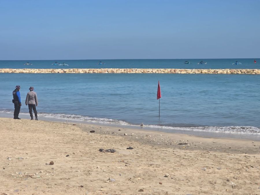 Polisi dan petugas SAR mengawasi tempat mayat tak dikenal ditemukan mengapung di sebelah barat batu pemecah gelombang depan patung selter baruna Pantai Kuta, Badung, Bali. (foto/hes)