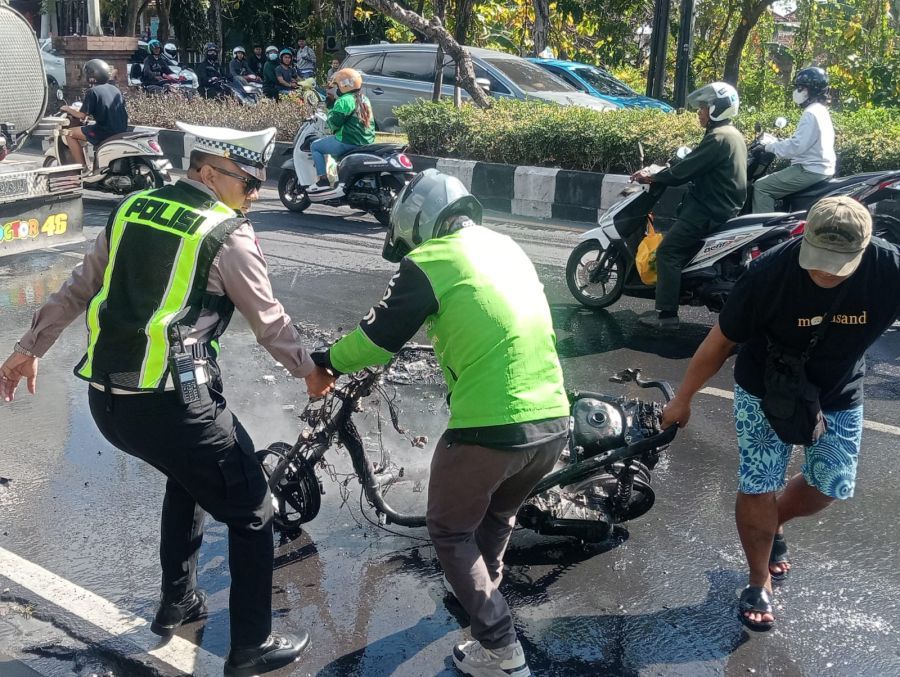 Polisi dan warga menangani sepeda motor yang ludes terbakar di kawasan Jalan Bypass Ngurah Rai, tepatnya di depan Bengkel Athena Motor, Lingkungan Mumbul, Kelurahan Benoa, Kecamatan Kuta Selatan, Badung, Bali. (foto/hes)