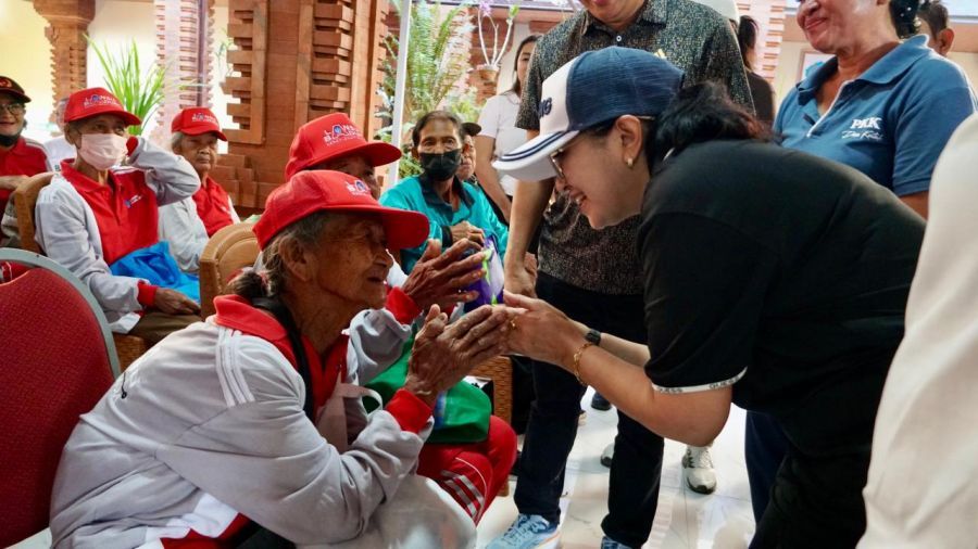 Ketua K3S Badung, Rasniathi Adi Arnawa menyerahkan bantuan kepada warga membutuhkan di Desa Kutuh. (foto/sukadana)