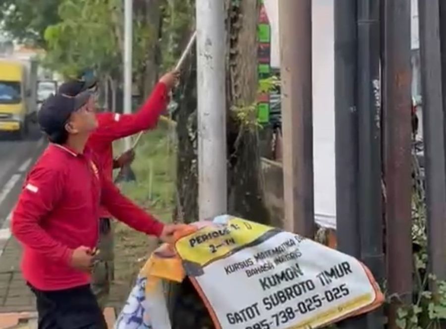 Petugas Satpol PP Kota Denpasar menertibkan media promosi ilegal di fasilitas umum. (sukadana)