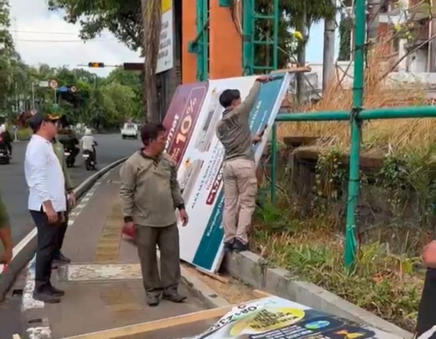 Satpol PP Kota Denpasar menertibkan berbagai media promosi yang terpasang di fasilitas umum, di Kota Denpasar, Bali, Kamis (8/10/2026). (foto/sukadana)