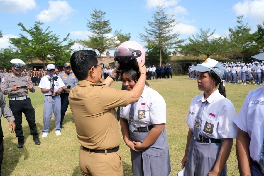 Bupati Badung I Wayan Adi Arnawa menyerahkan bantuan helm kepada perwakilan siswa-siswi SMA Negeri 2 Abiansemal serangkaian Peringatan Hari Perhubungan Nasional Ke-55 Tahun 2026 tingkat Kabupaten Badung, Bali, Senin (14/9/2026). (foto/adi)