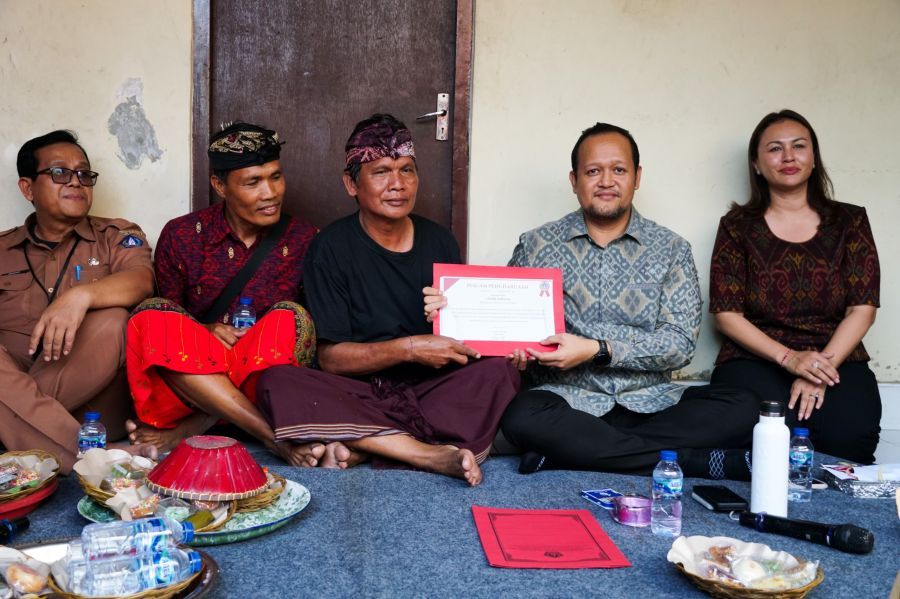Wabup Badung Bagus Alit Sucipta didampingi Ketua GOW Badung Nyonya Yunita Alit Sucipta menyerahkan Piagam Penghargaan Tertib Administrasi Pengurusan Akta Kematian dan Kartu Keluarga (KK) kepada ahli waris I Made Subagia di Banjar Belawan, Desa Dauh Yeh Cani, Abiansemal, Badung, Bali, Senin (27/7/2026). (foto/adi)