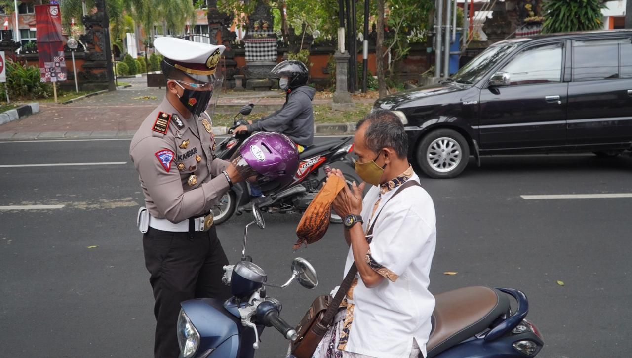 podiumnews.com-Polres Denpasar Bagikan Helm Operasi Lempuyang 2020