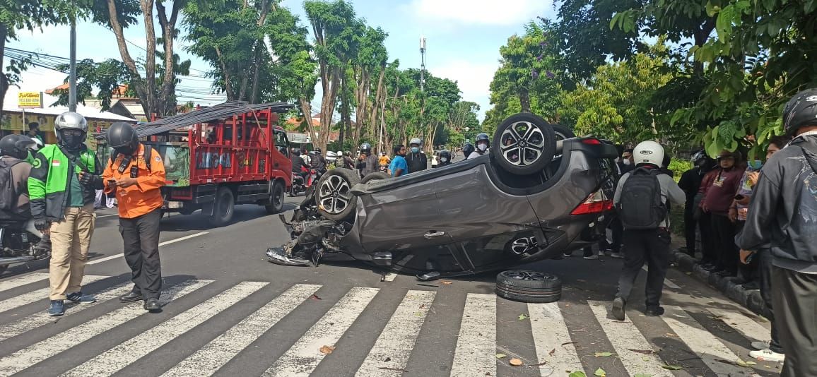 podiumnews.com-Diduga Sopir Ngantuk Sebuah Mobil Tabrak Pohon dan Sepeda Motor di Denpasar