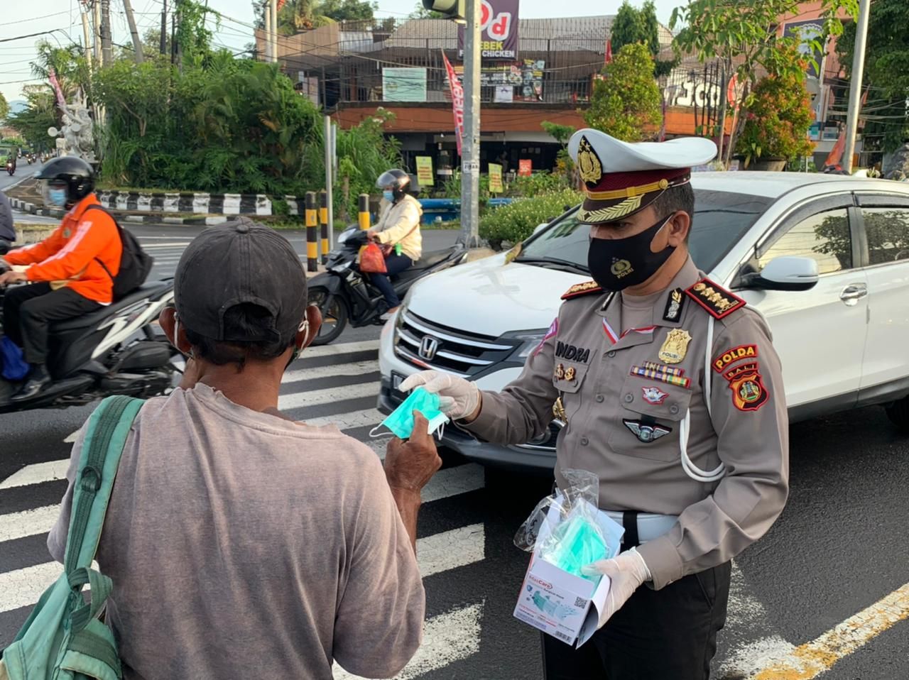 podiumnews.com-Dirlantas Polda Bali Bagikan Ratusan Masker ke Pengendara Motor