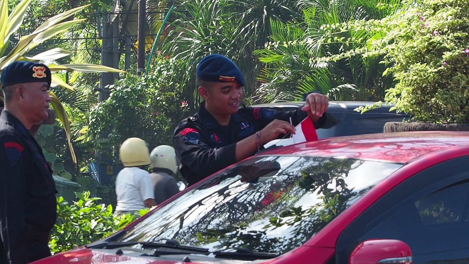 Brimob Polda Bali Bagikan Bendera Merah Putih ke Pengendara