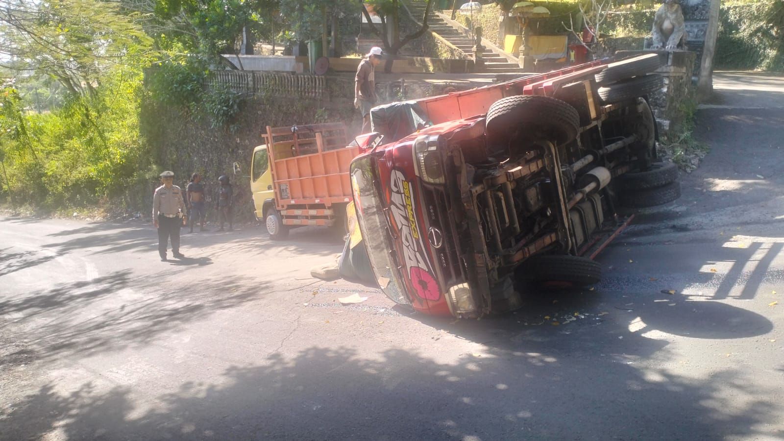 podiumnews.com-Truk Bermuatan 250 Sak Semen Terguling di Goa Gong Jimbaran