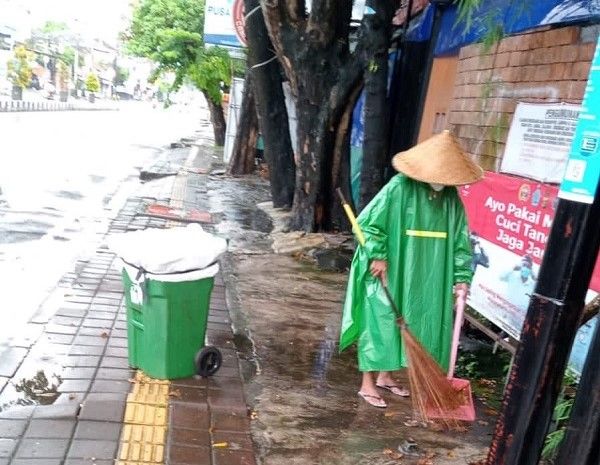 Tetap Bersihkan Kota di Tengah Guyuran Hujan
